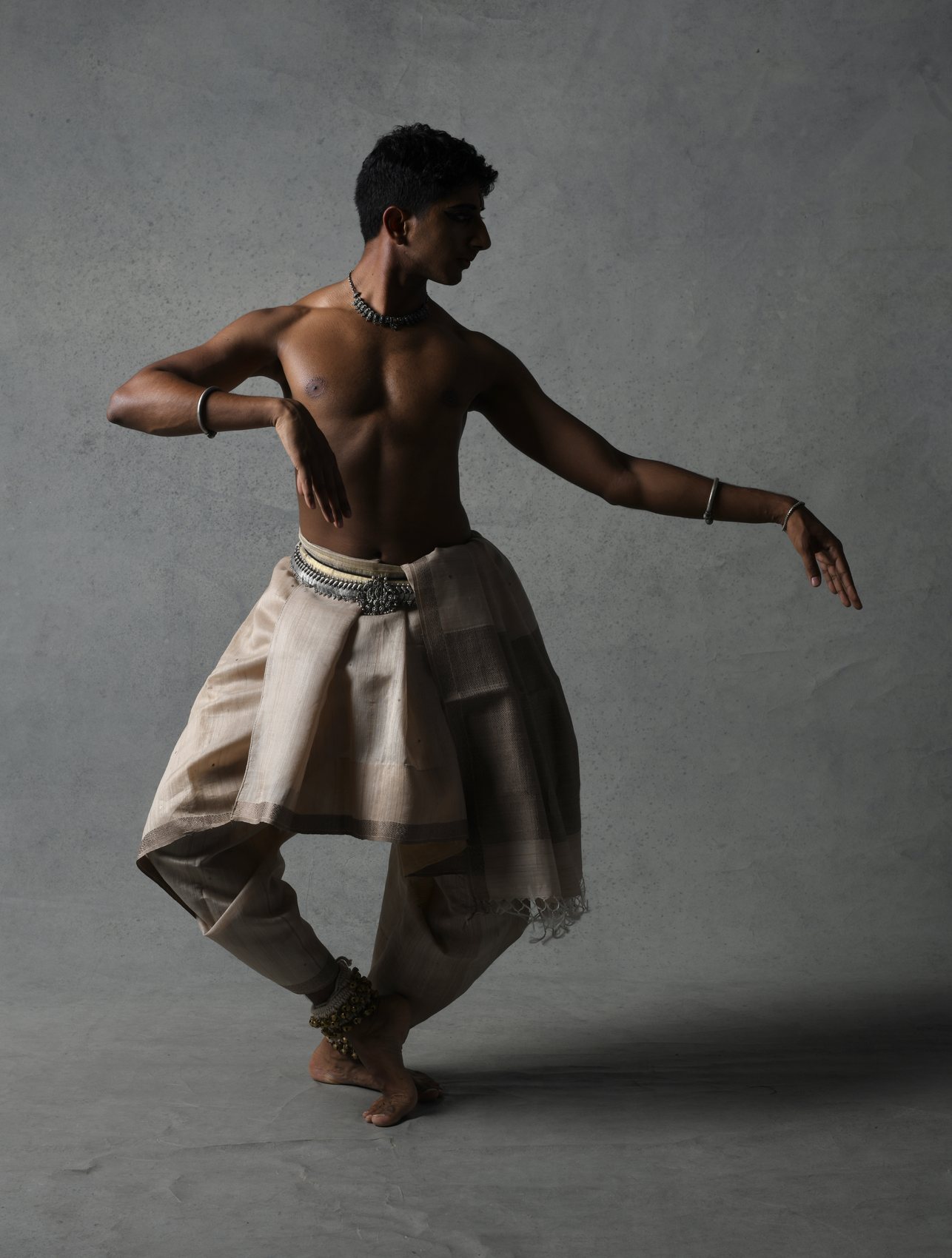 Vivek Ramanan mid-movement in a grey studio